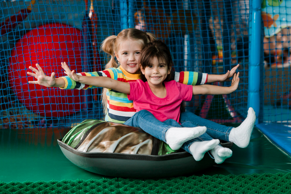 Cheerful little children spending time at daycare indoor playground
