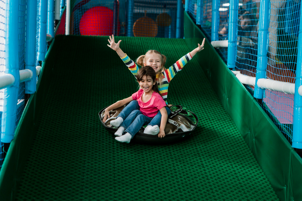 Cheerful little children spending time at daycare indoor playground